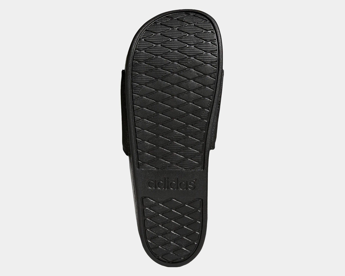 Adidas Adilette Comfort Slides outsole in black showing textured grip pattern and embossed logo.