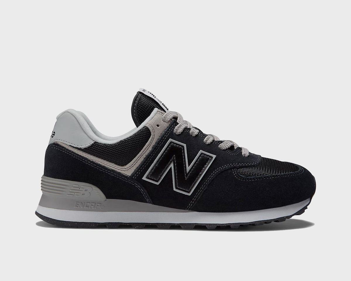 New Balance 574 Core sneakers in black and gray with suede and mesh upper, ENCAP midsole, and logo detailing, side view.
