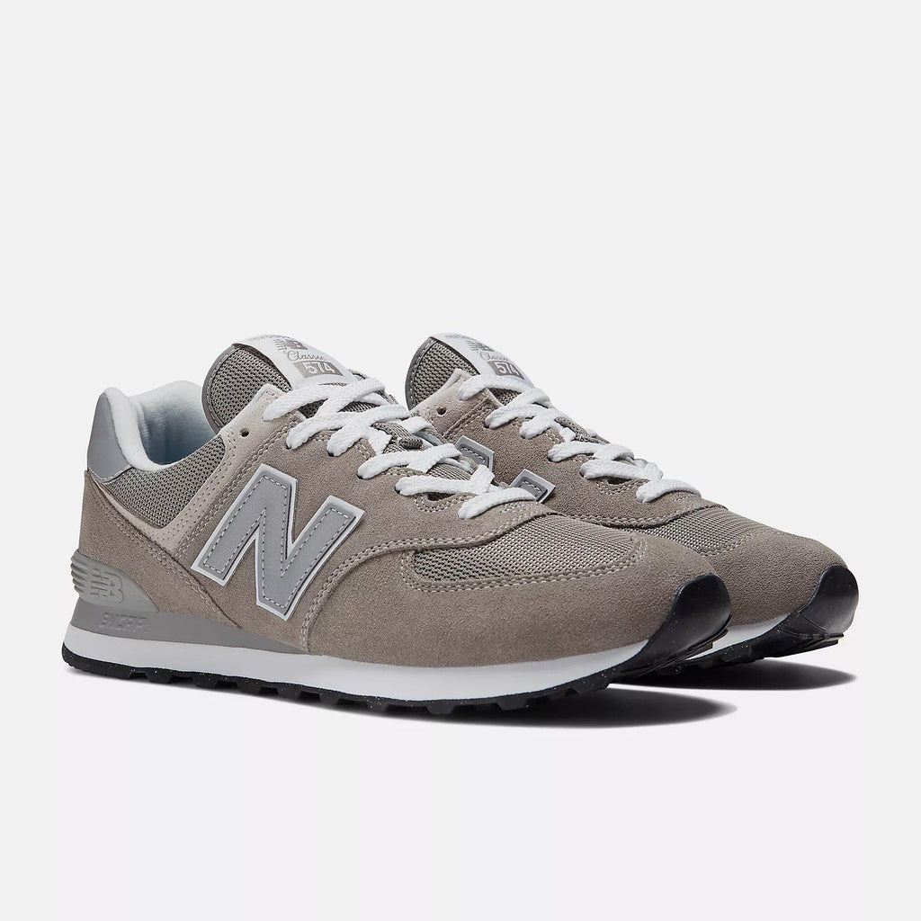 New Balance 574 Core sneakers in taupe gray with suede and mesh upper, white laces, and EVA midsole, angled front view.
