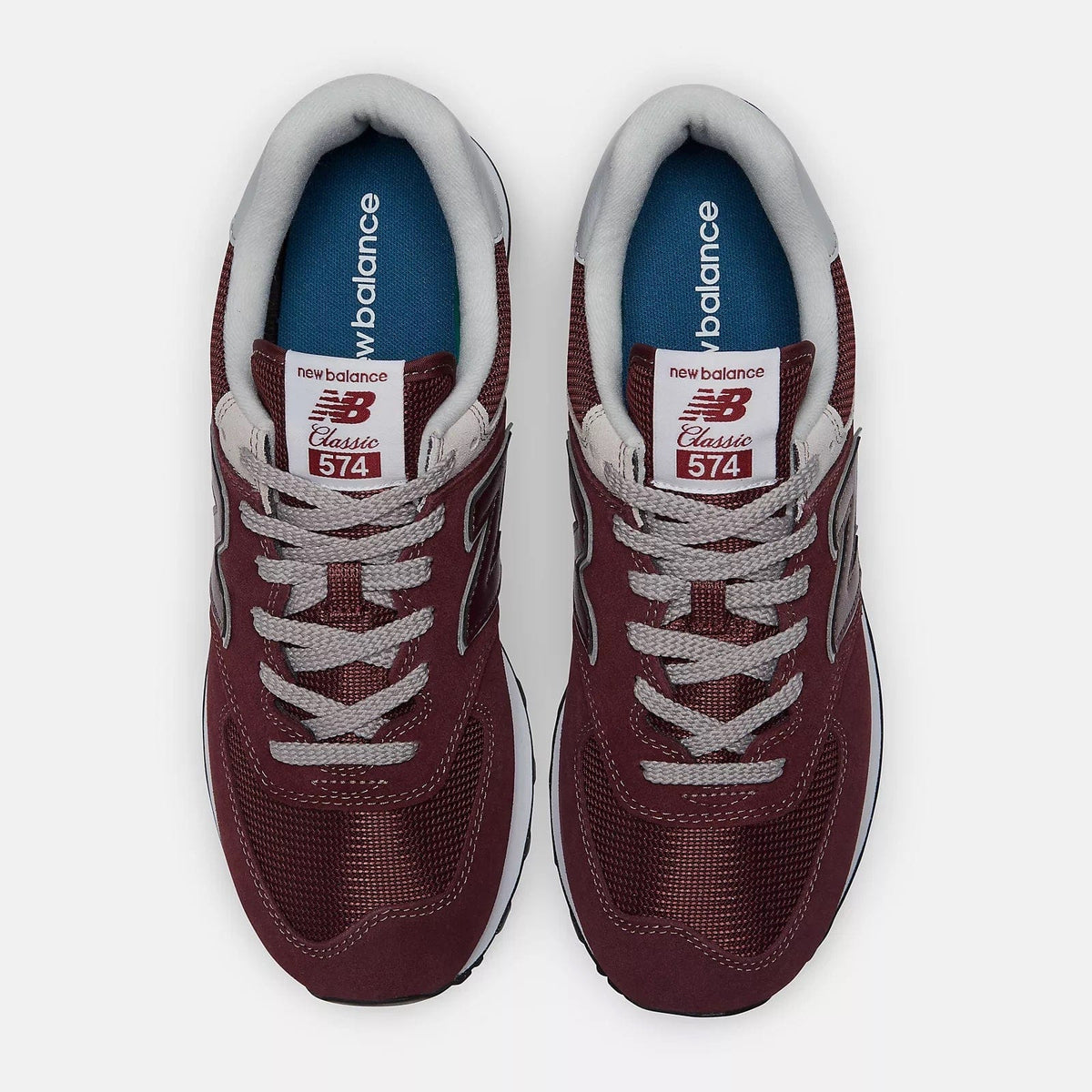 New Balance 574 Core sneakers in burgundy with mesh upper, suede overlays, and gray laces, top view.