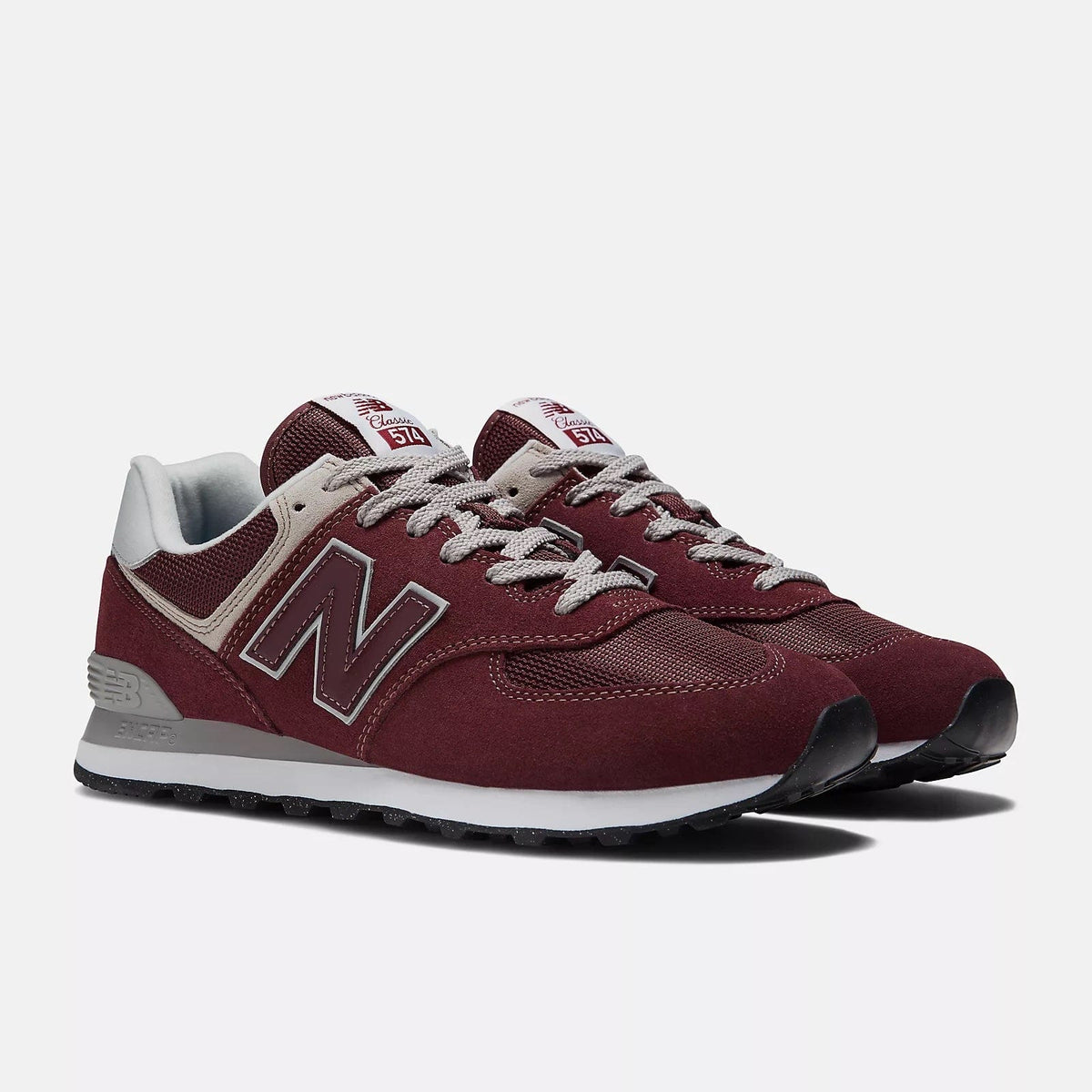 New Balance 574 Core sneakers in burgundy with suede and mesh upper, white midsole, and gray laces, front-side view.