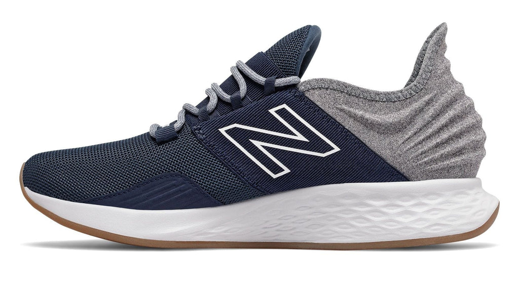 New Balance Fresh Foam Roav Tee Shirt running shoes side view in navy blue and gray with mesh upper, cushioned sole, and textured heel design.
