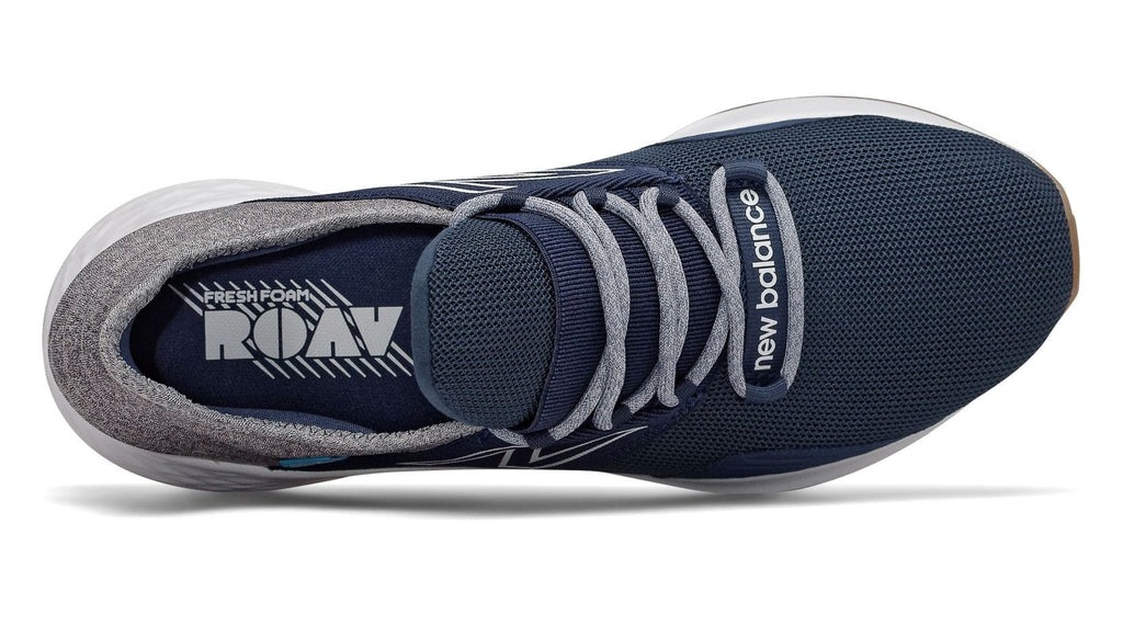 New Balance Fresh Foam Roav Tee Shirt running shoes in navy blue with breathable mesh upper and gray laces, top view.