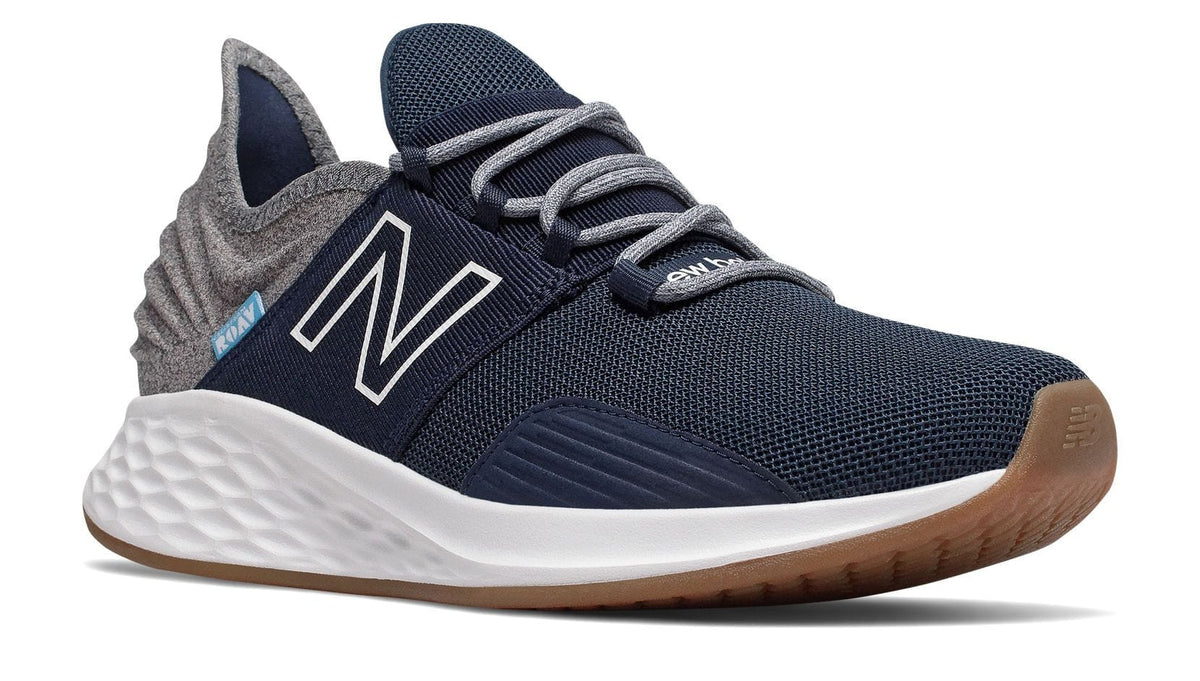 New Balance Fresh Foam Roav Tee Shirt running shoes in navy blue with gray heel, mesh upper, Fresh Foam midsole, and gum outsole, side view.