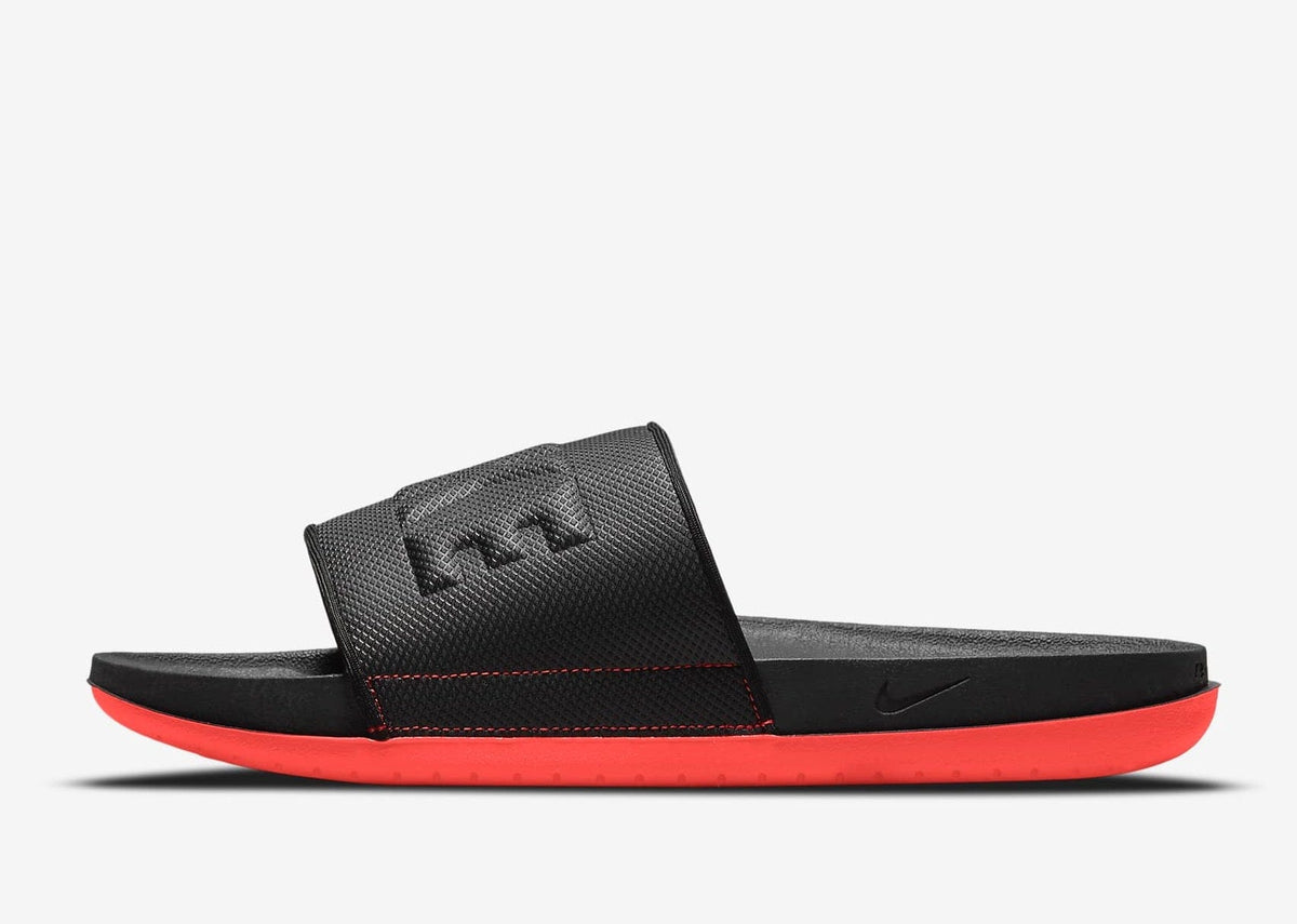 Nike Offcourt Slide sandals in black with textured strap and soft foam sole in vibrant red, side view.